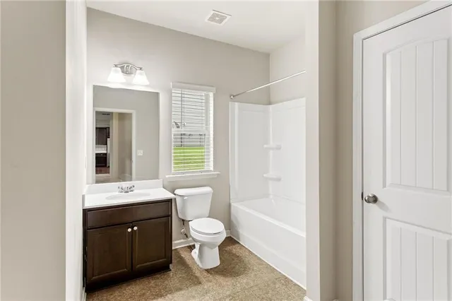 a bathroom with a bathtub shower sink vanity mirror and toilet