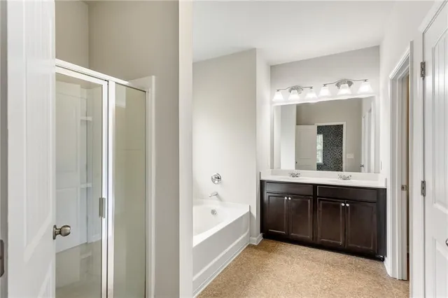 a spacious bathroom with a tub sink and mirror