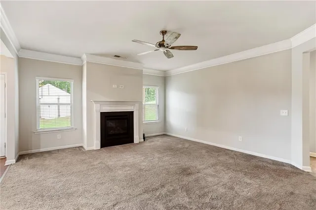 an empty room with windows and fireplace
