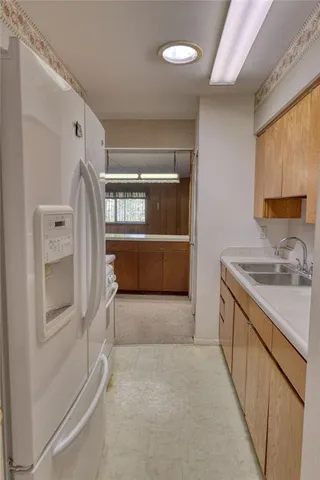 a kitchen with granite countertop a sink stove and refrigerator