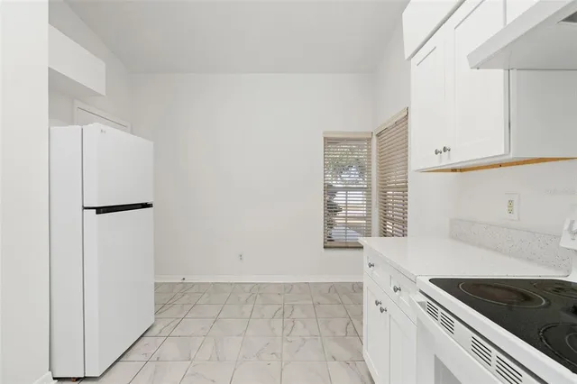 a kitchen with white cabinets and white appliances