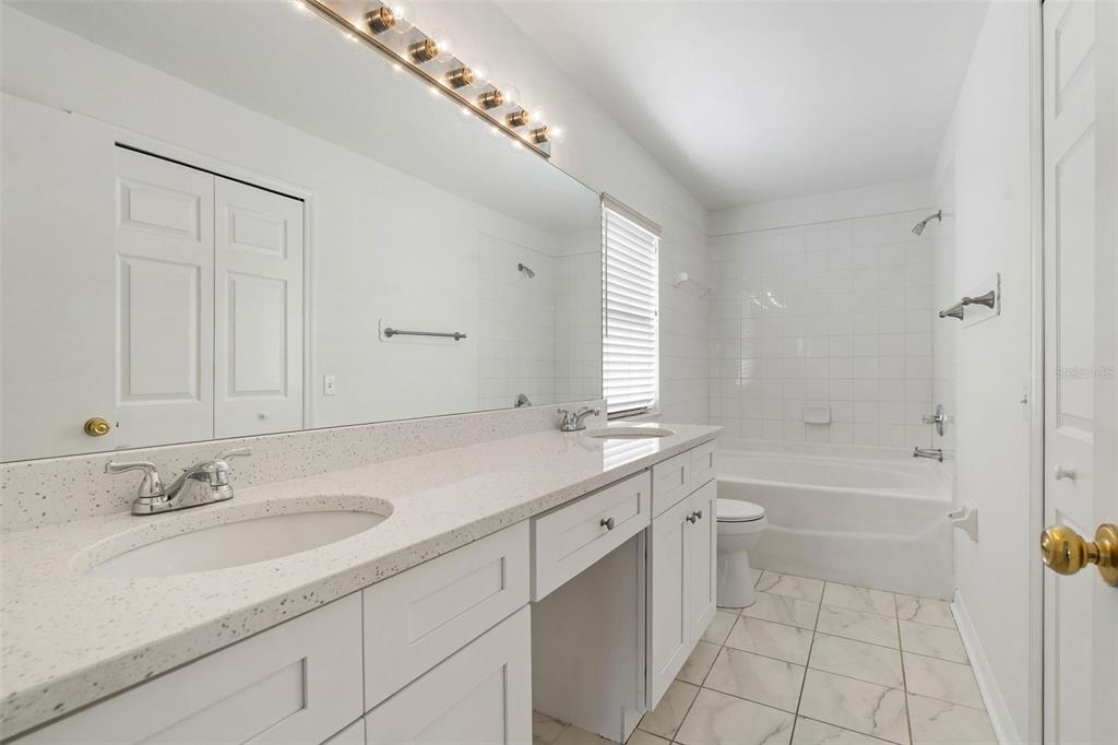 1504 Silktree Court Brandon, FL 33511 - Photo 17 of 26 a bathroom with a sink double vanity granite tub shower and a mirror