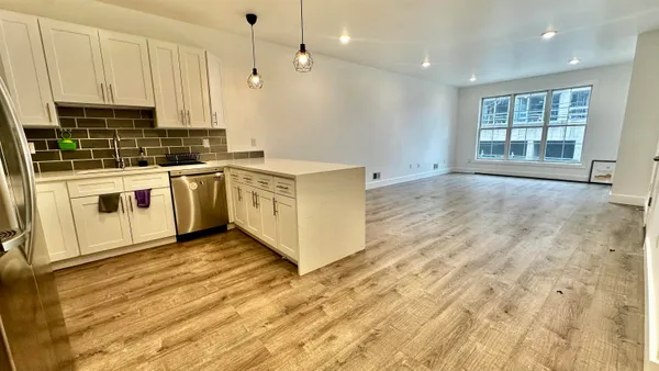 a kitchen with stainless steel appliances granite countertop a stove a sink and white cabinets