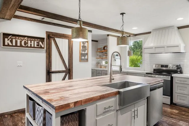 a kitchen with kitchen island a counter top a stove a sink and a refrigerator