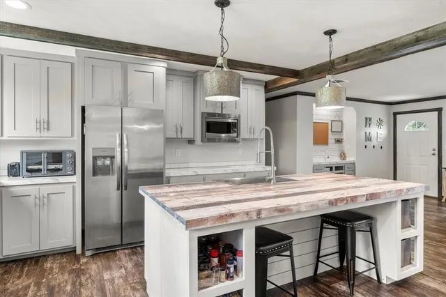 a kitchen with stainless steel appliances granite countertop a refrigerator a sink and a stove