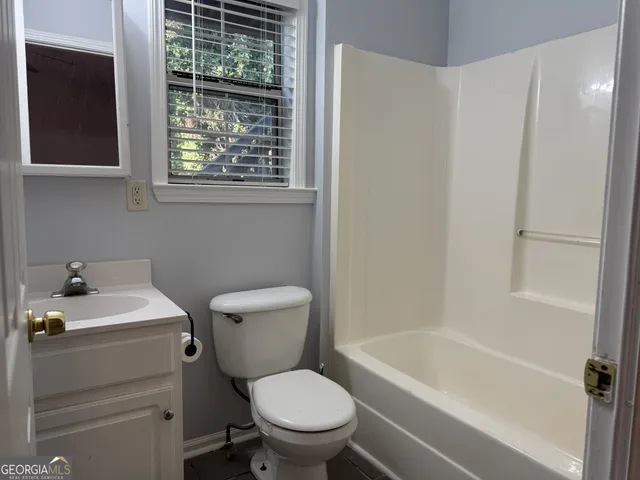 a white toilet sitting next to a bath tub