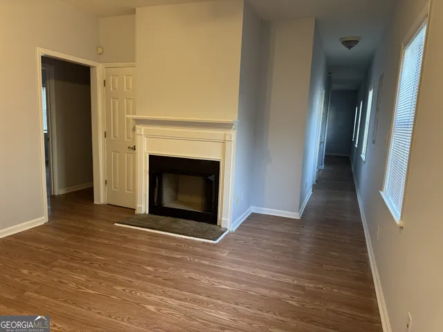 a view of a livingroom with wooden floor and a fireplace