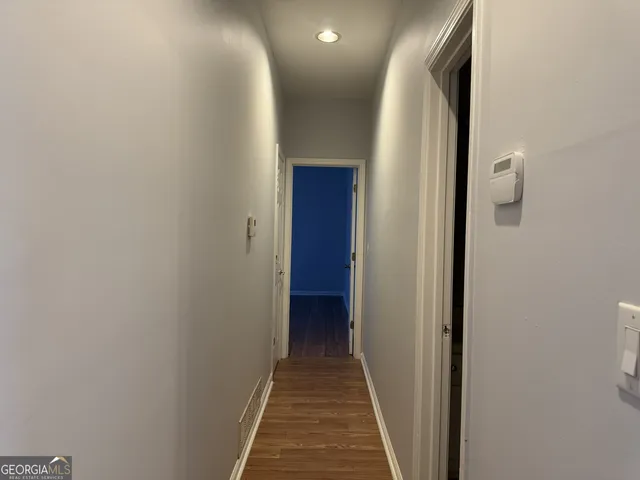 a view of a hallway with wooden floor