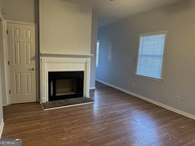 a view of a livingroom with a fireplace wooden floor and staircase