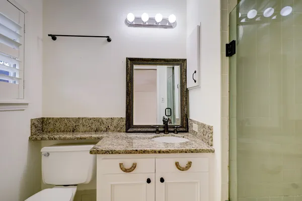 a bathroom with a granite countertop sink and a mirror