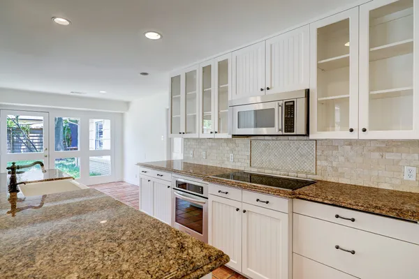 a kitchen with stainless steel appliances granite countertop a stove and a sink
