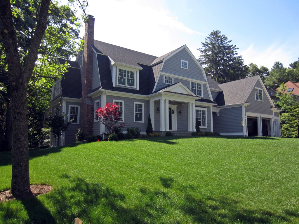 a front view of a house with a yard and trees