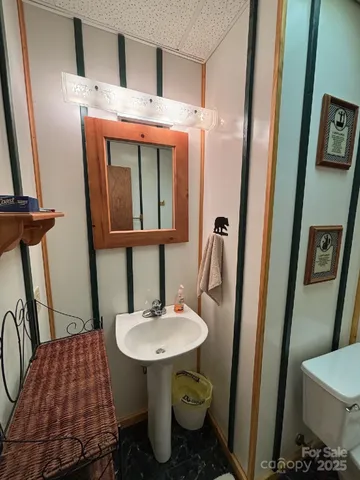 a bathroom with a sink toilet and a mirror