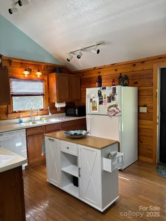 a kitchen with stainless steel appliances granite countertop a refrigerator a sink and a stove