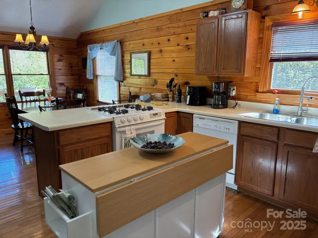 a kitchen with a stove a sink a counter space and a window