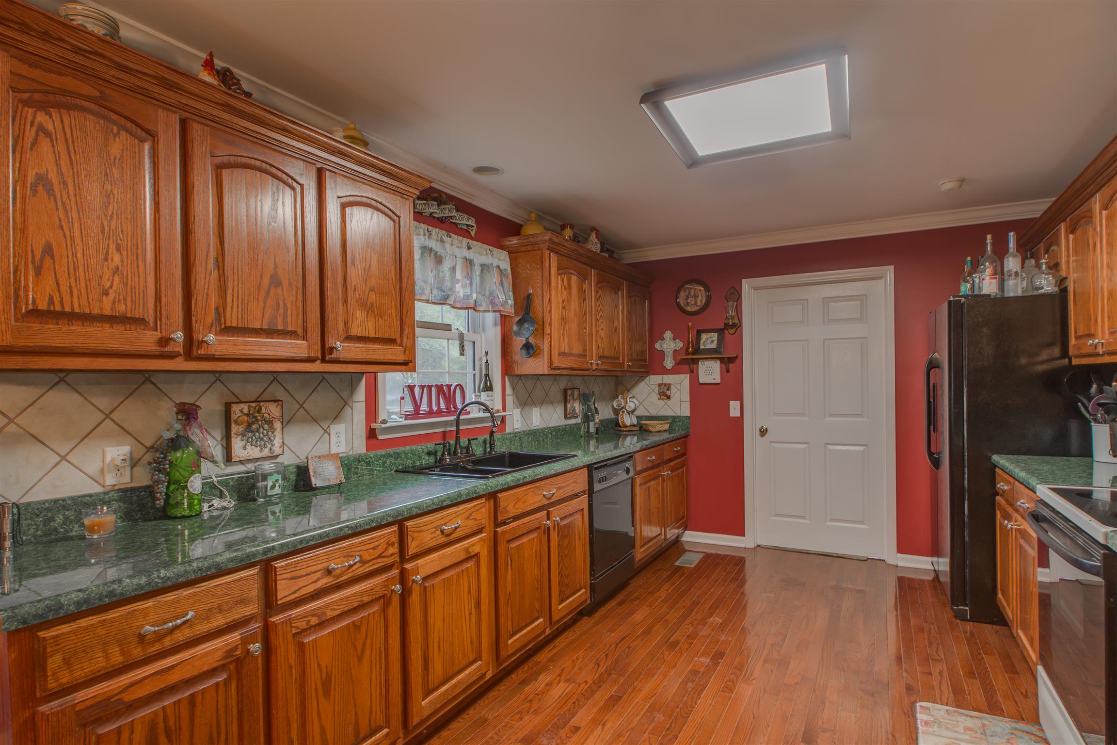 2943 Robert Skelley Road Columbia, TN 38401 - Photo 12 of 30 a kitchen with stainless steel appliances granite countertop wooden cabinets a sink and dishwasher a stove top oven with wooden floor
