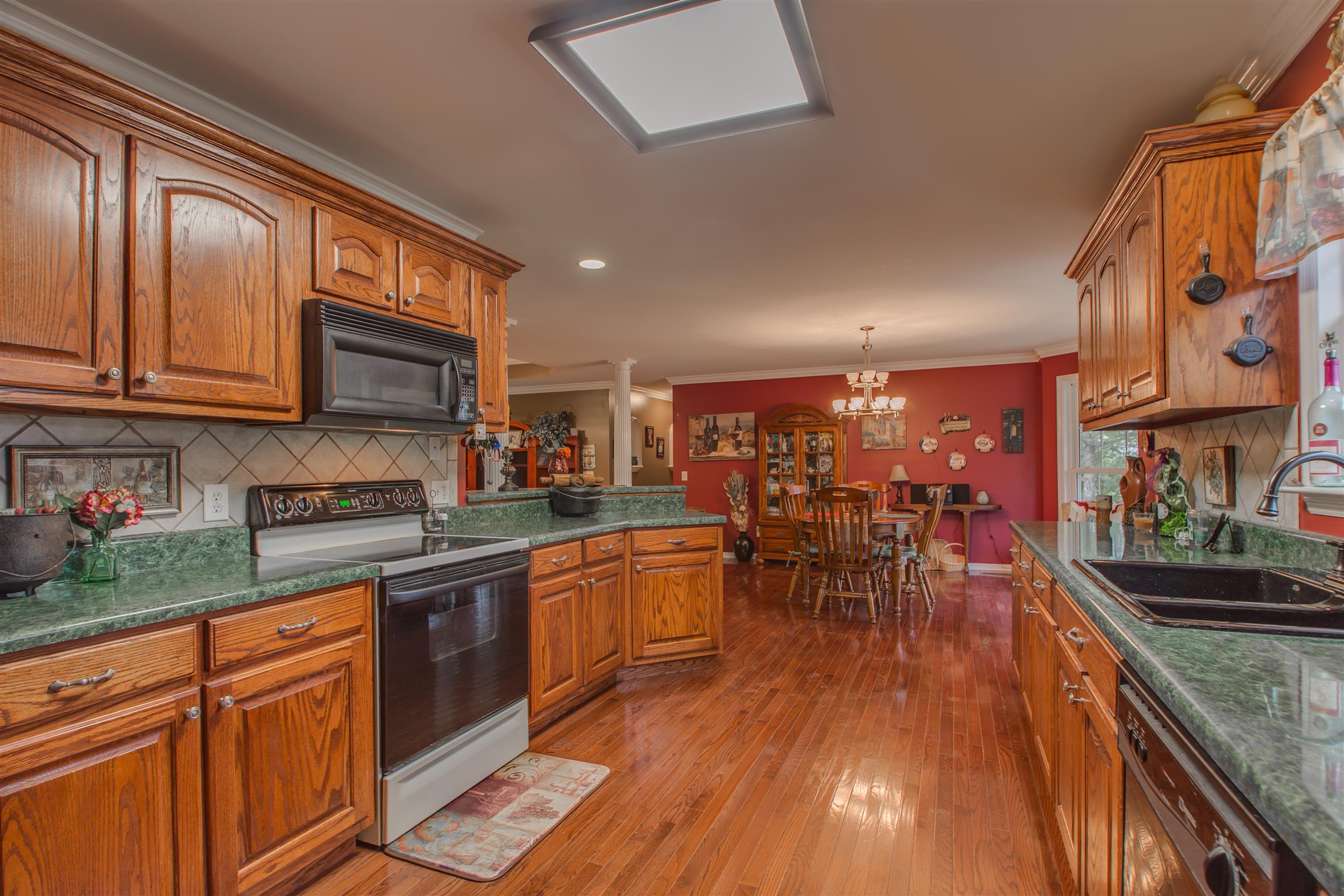 2943 Robert Skelley Road Columbia, TN 38401 - Photo 13 of 30 a kitchen with stainless steel appliances granite countertop wooden floors and wooden cabinets