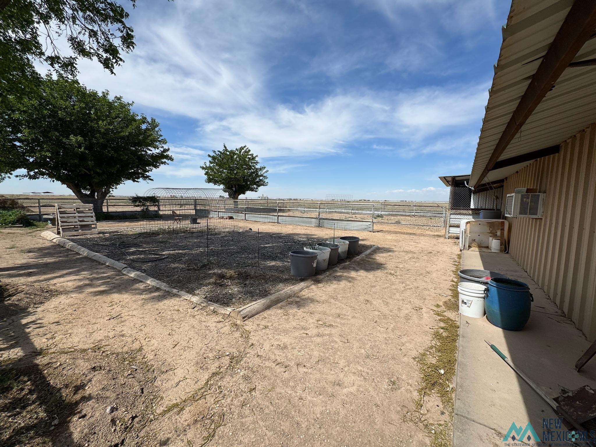 6660 Cherokee Road Dexter, NM 88230 - Photo 23 of 46 Expansive outdoor area featuring a wide field, perimeter fencing, and mature trees
