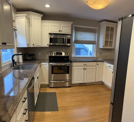 a kitchen with stainless steel appliances granite countertop a stove a sink and a microwave