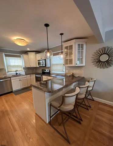 a kitchen with granite countertop a table chairs stove and wooden floor
