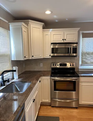 a kitchen with appliances a sink and cabinets