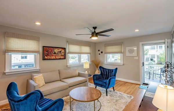 a living room with furniture a wooden floor and a window