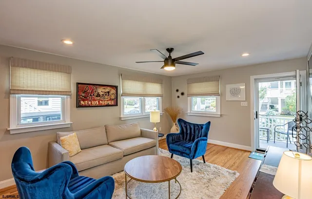 a living room with furniture a wooden floor and a window