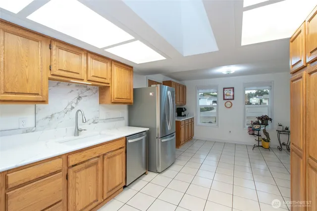 a kitchen with stainless steel appliances granite countertop a refrigerator and a sink