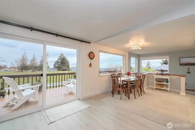 a dining room with furniture and a floor to ceiling window