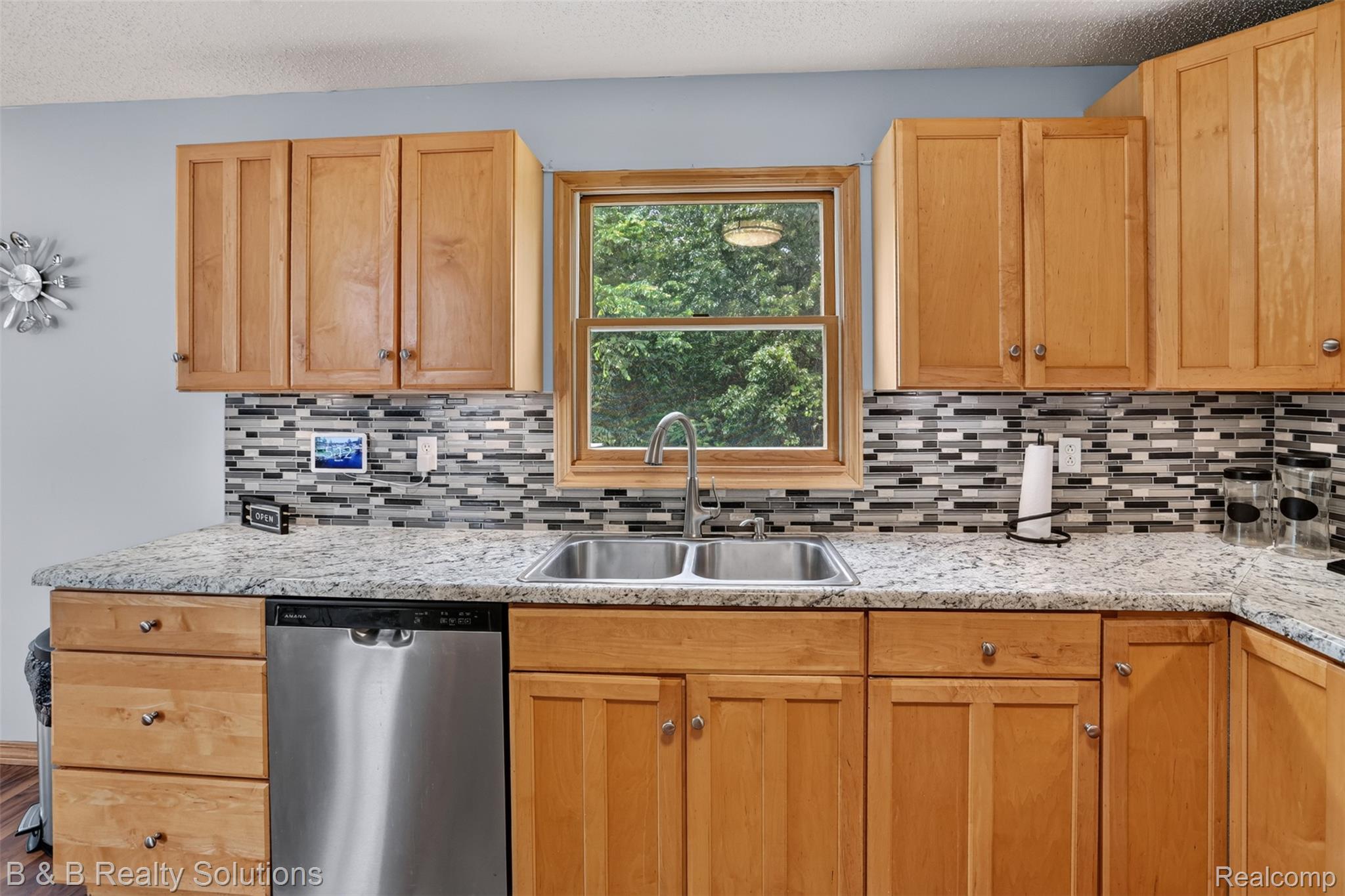 3097 East Burnside Road North Branch, MI 48461 - Photo 11 of 52 Kitchen featuring light wood cabinetry, granite-finish countertops, stainless steel double basin sink, stainless steel dishwasher, and a mosaic tile backsplash