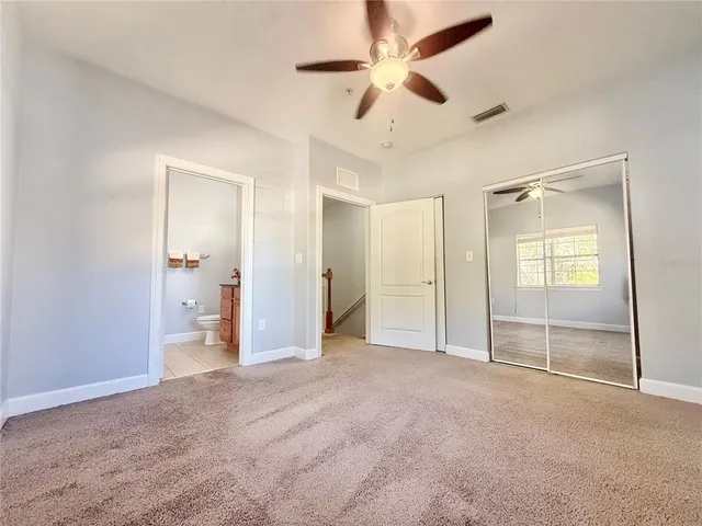 an empty room with windows and fan