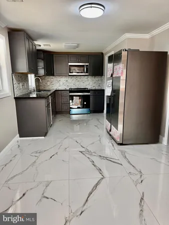 a kitchen with stainless steel appliances granite countertop a refrigerator a stove a sink a microwave and island