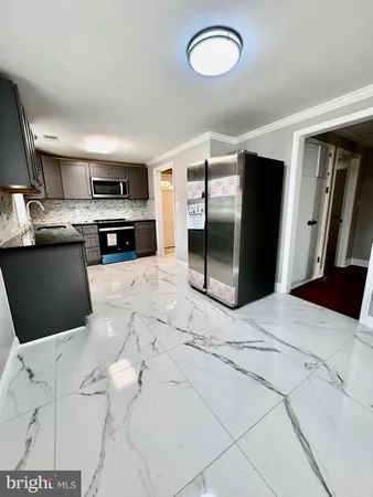 a kitchen with stainless steel appliances kitchen island granite countertop a refrigerator and stove