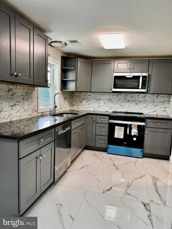 a kitchen with stainless steel appliances granite countertop a sink and a stove