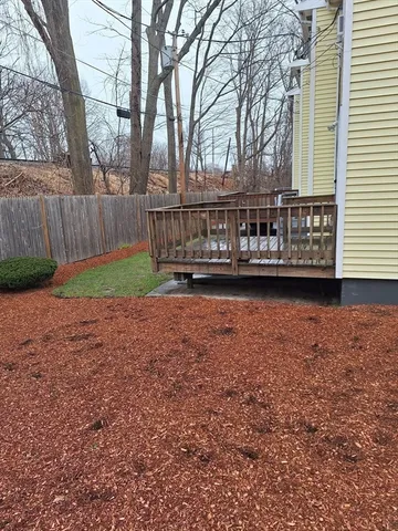 a view of a house with backyard and trees