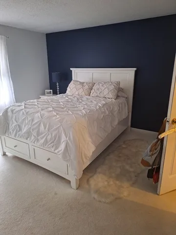 a bed sitting in a bedroom next to a window