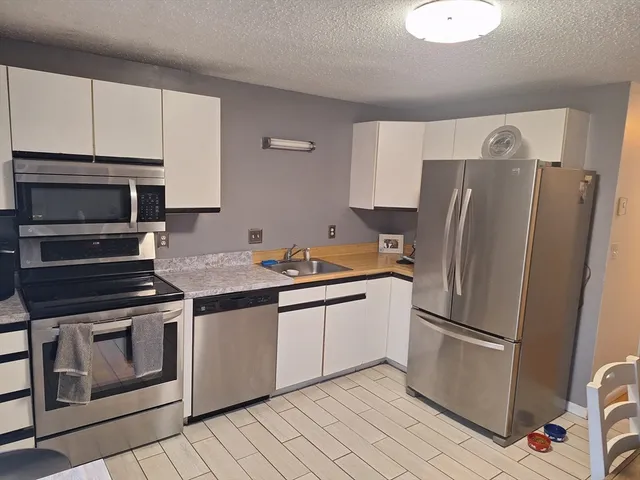 a kitchen with stainless steel appliances a refrigerator stove and microwave
