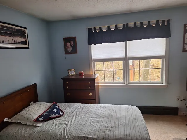 a bedroom with a bed dresser and a window