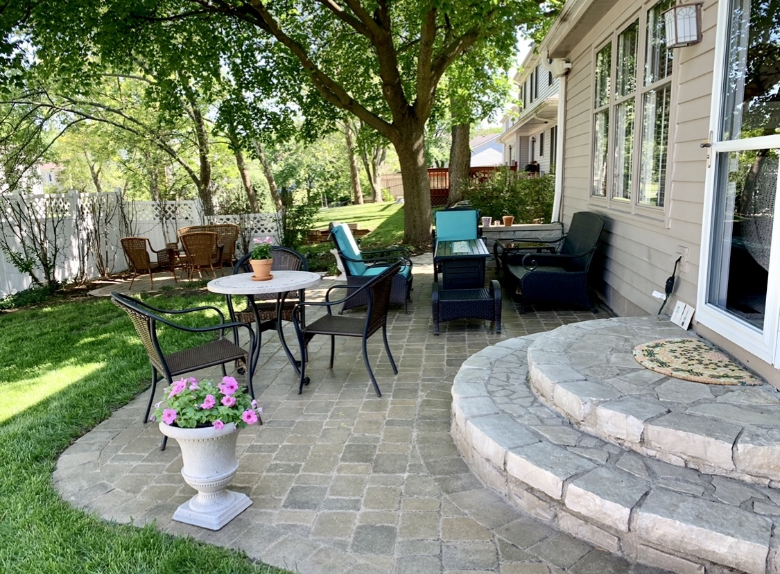 2706 Pebblebrook Lane Rolling Meadows, IL 60008 - Photo 26 of 34 a view of a patio with a dining table and chairs and a fire pit