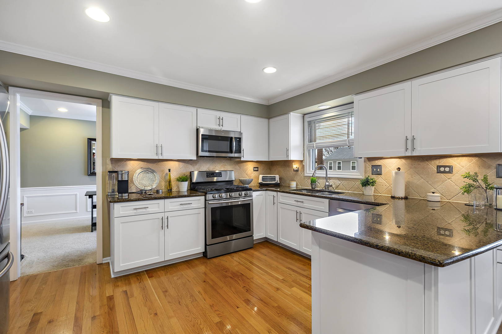 2706 Pebblebrook Lane Rolling Meadows, IL 60008 - Photo 8 of 34 a kitchen with granite countertop a stove top oven a sink dishwasher and a refrigerator with wooden floor