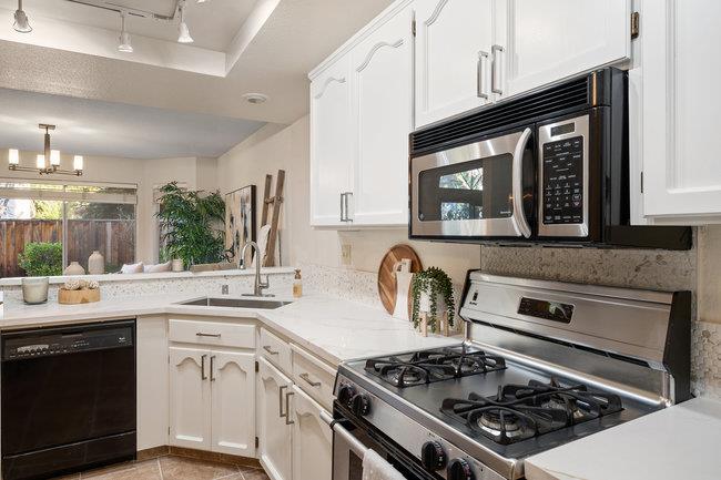 2101 Ornellas Drive Milpitas, CA 95035 - Photo 9 of 17 a kitchen with stainless steel appliances a stove a sink dishwasher and cabinets with wooden floor