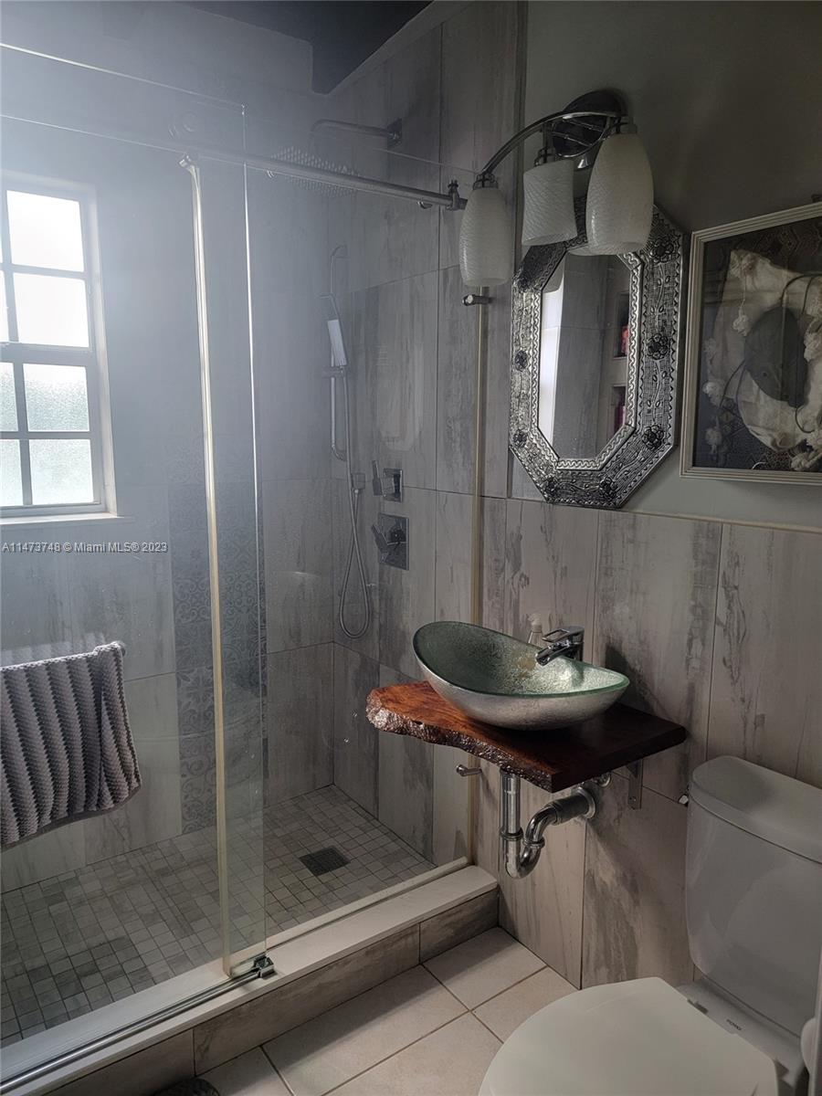 Olympia Heights Miami, FL 33165 - Photo 27 of 45 a bathroom with a sink a mirror and shower