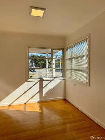 a view of a room with wooden floor and a window
