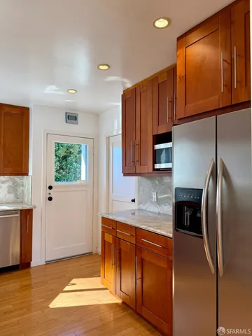 a kitchen with stainless steel appliances granite countertop a refrigerator and a sink
