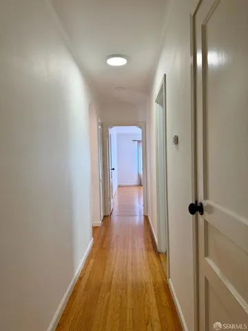 a view of a room with wooden floor and a bathroom