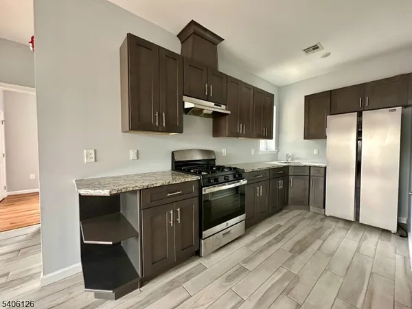 a kitchen with stainless steel appliances granite countertop a stove a sink and a refrigerator
