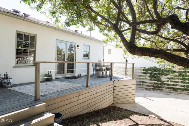 a roof deck with table and chairs and wooden floor