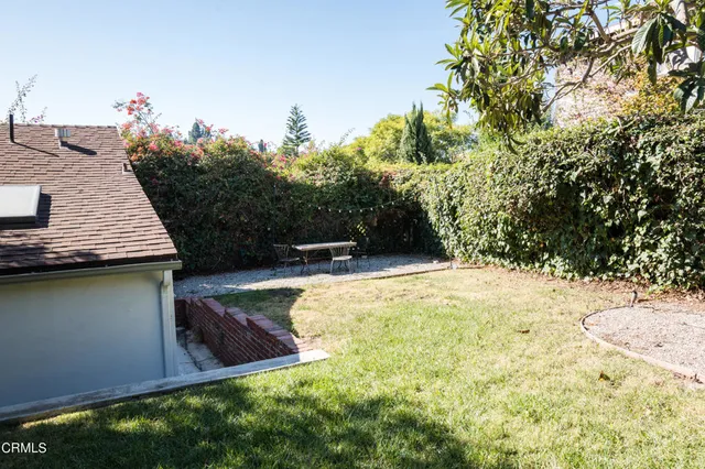 a view of backyard with swimming pool and seating space