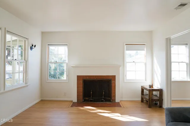 a view of an empty room with window and fire place