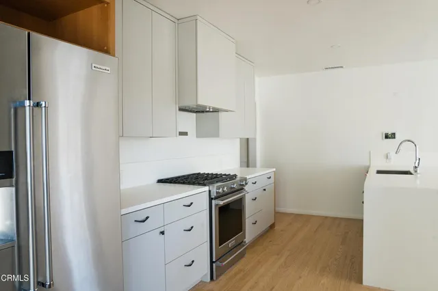 a kitchen with a stove a sink and a refrigerator